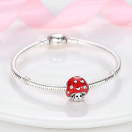 Bracelet argenté avec charm champignon rouge à pois blancs, style mignon et délicat.