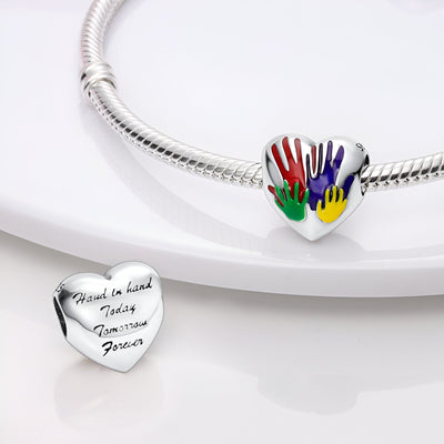 Charm cœur en argent avec quatre mains colorées rouge, vert, jaune et violet, bracelet serpent.