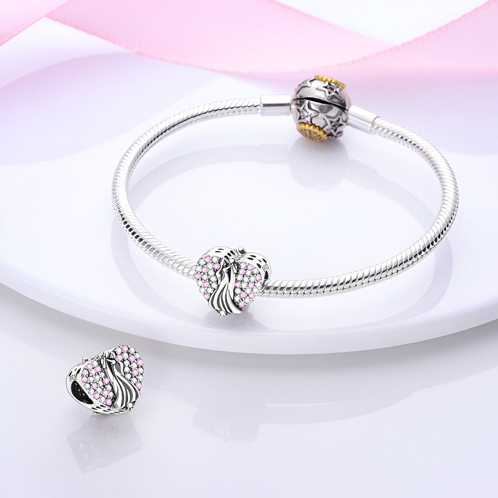 Bracelet argenté avec charm cœur orné de zircons roses et bague décorative assortie.