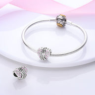 Bracelet argenté avec charm cœur orné de zircons roses et bague décorative assortie.