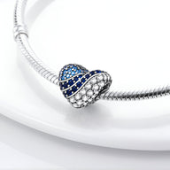 Charm cœur en métal argenté avec zirconiums bleus et blancs, modèle Drusilla, brillant et élégant.