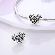 Charm en argent en forme de cœur avec motifs entrelacés pour bracelet.