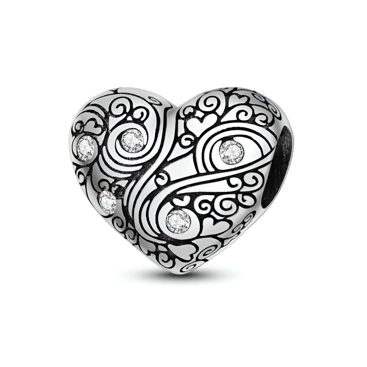 Charm cœur en argent gravé de motifs arabesques avec cinq petits strass brillants.