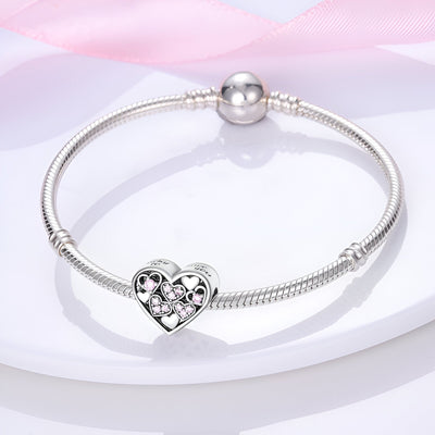 Bracelet argent avec charm coeur incrusté de petits coeurs roses scintillants.