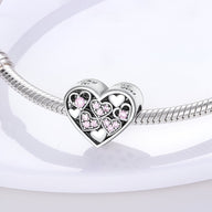Charm cœur en argent avec petits cœurs roses incrustés, monté sur un bracelet serpent argenté.