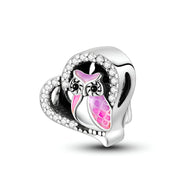 Charm en argent en forme de cœur avec hibou rose et détails en strass blancs.