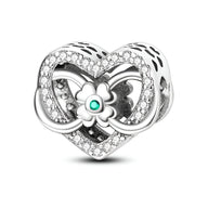 Charm cœur en argent avec trèfle et symbole infini, serti de pierres blanches et détail turquoise au centre du trèfle.