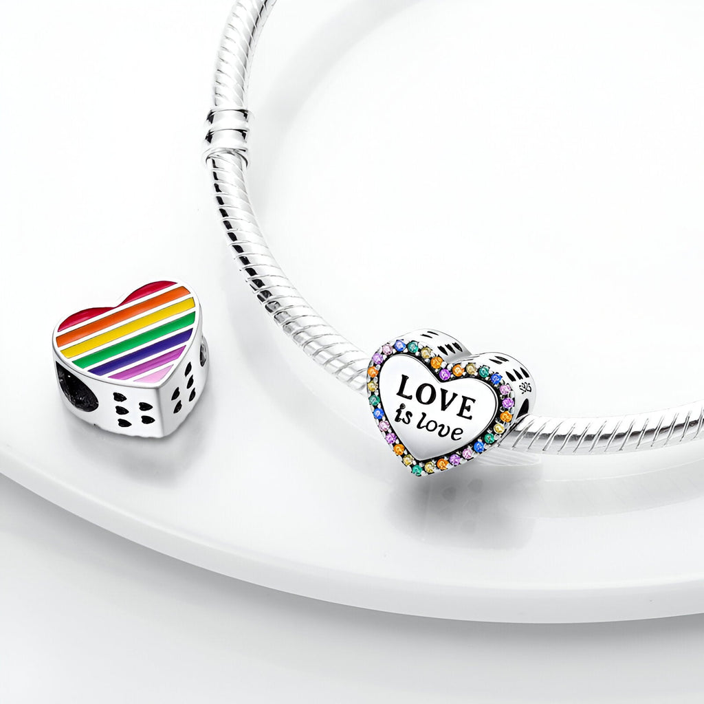 Charm cœur en argent avec inscription "Love is love" et motifs arc-en-ciel sur bracelet métallique, modèle Yolanda.