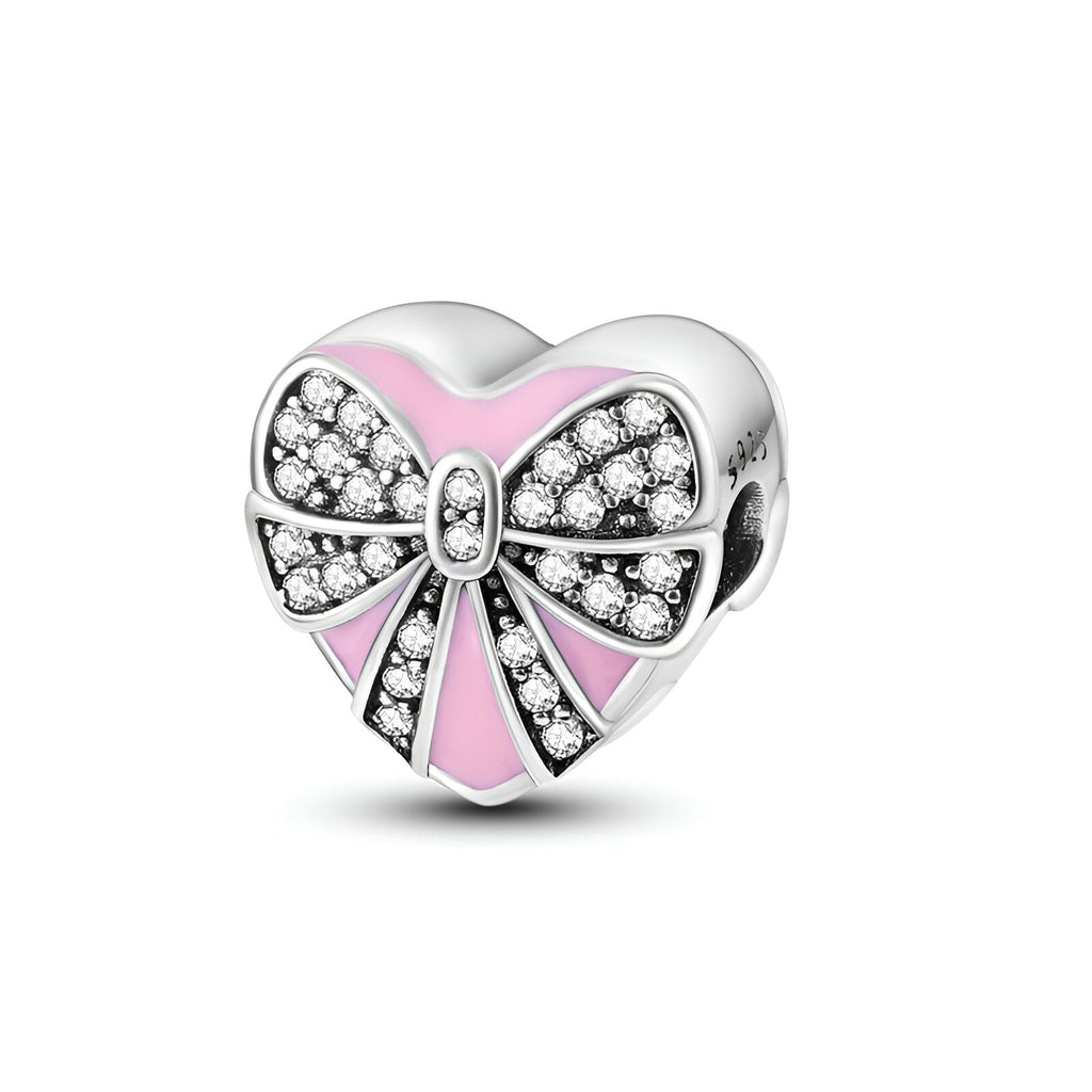 Charm cœur en argent avec nœud ruban rose et pavé de pierres brillantes.