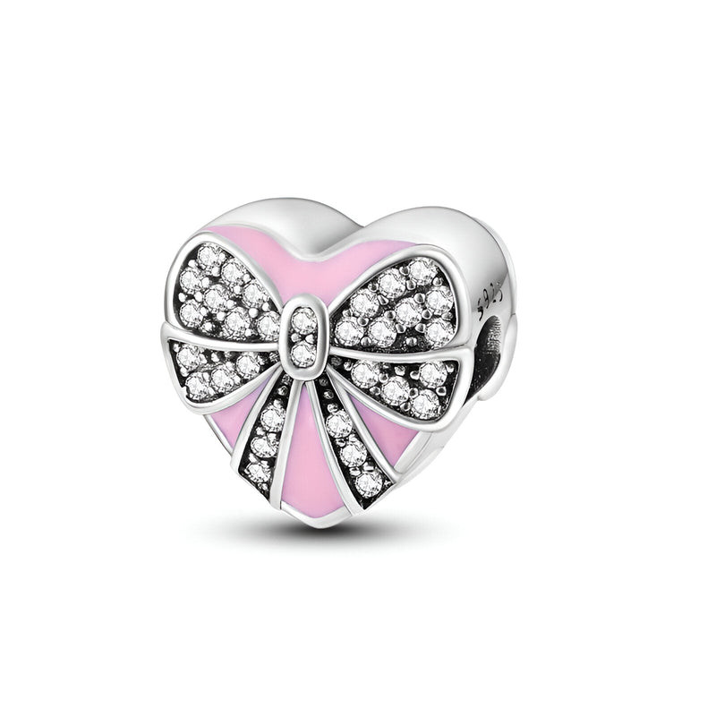 Charm cœur en argent avec nœud ruban rose et pavé de pierres brillantes.
