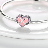 Charm en forme de cœur rose avec symbole infini en métal argenté sur bracelet serpent argenté.