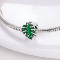 Charm feuille verte émaillée verte en forme de feuille de monstera sur bracelet en métal argenté.