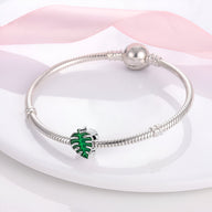 Bracelet argenté fin avec pendentif feuille verte émaillée, style délicat et naturel.