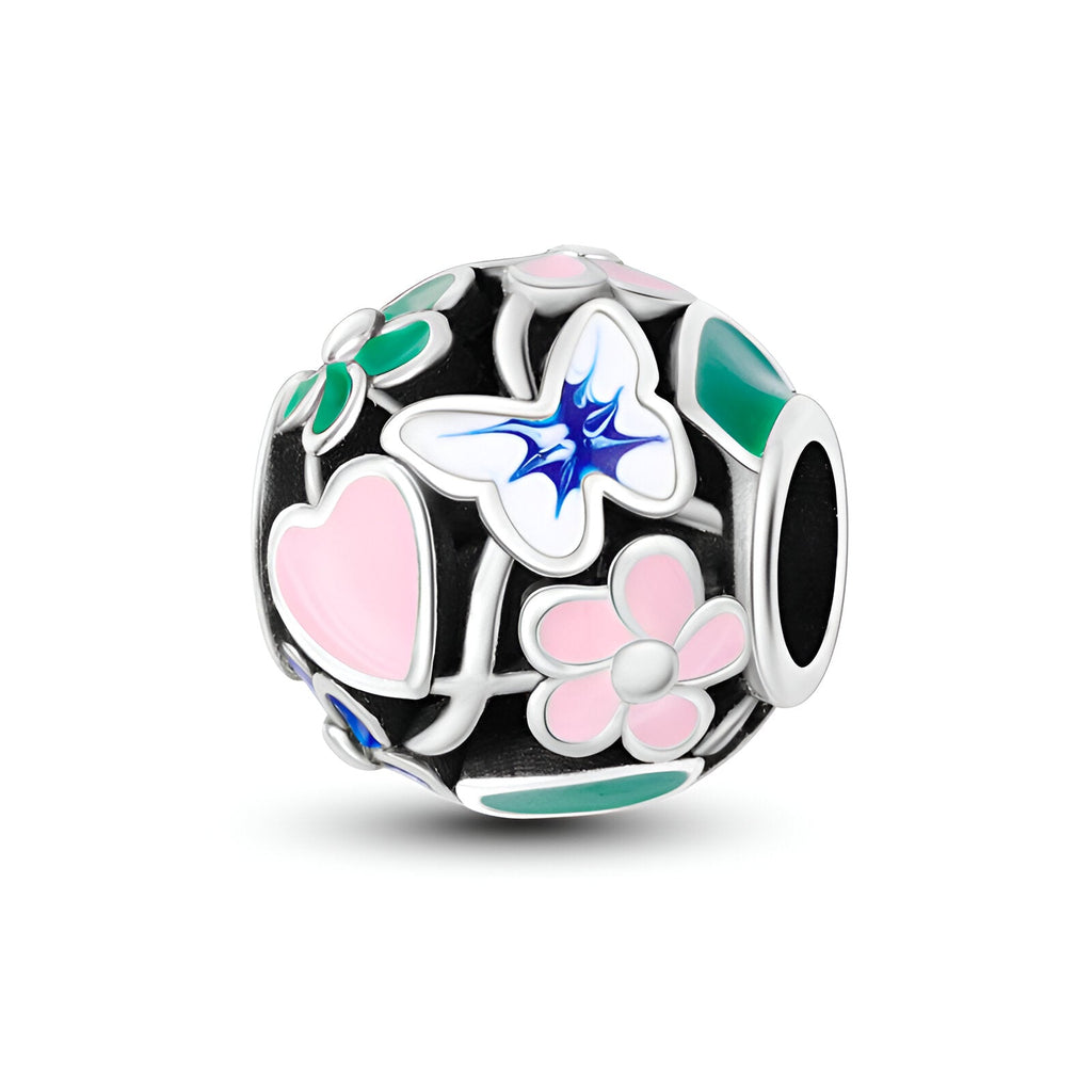 Charm rond en argent avec fleurs colorées et papillon bleu détaillé.