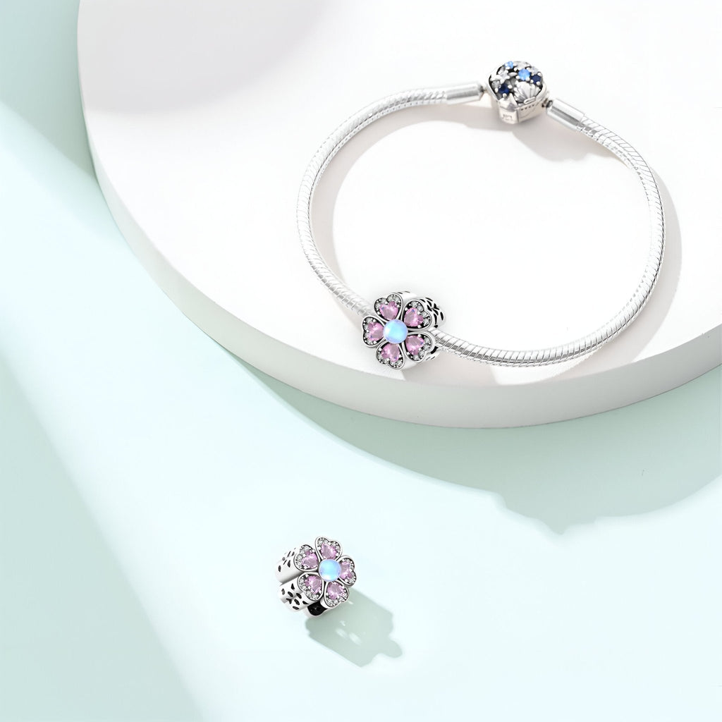 Bracelet argent avec charm fleur rose scintillante et pendentif assorti en forme de fleur.