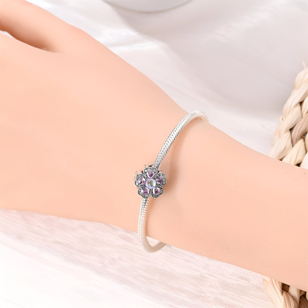 Bracelet argent avec charm fleur rose scintillante et détails en strass multicolores.