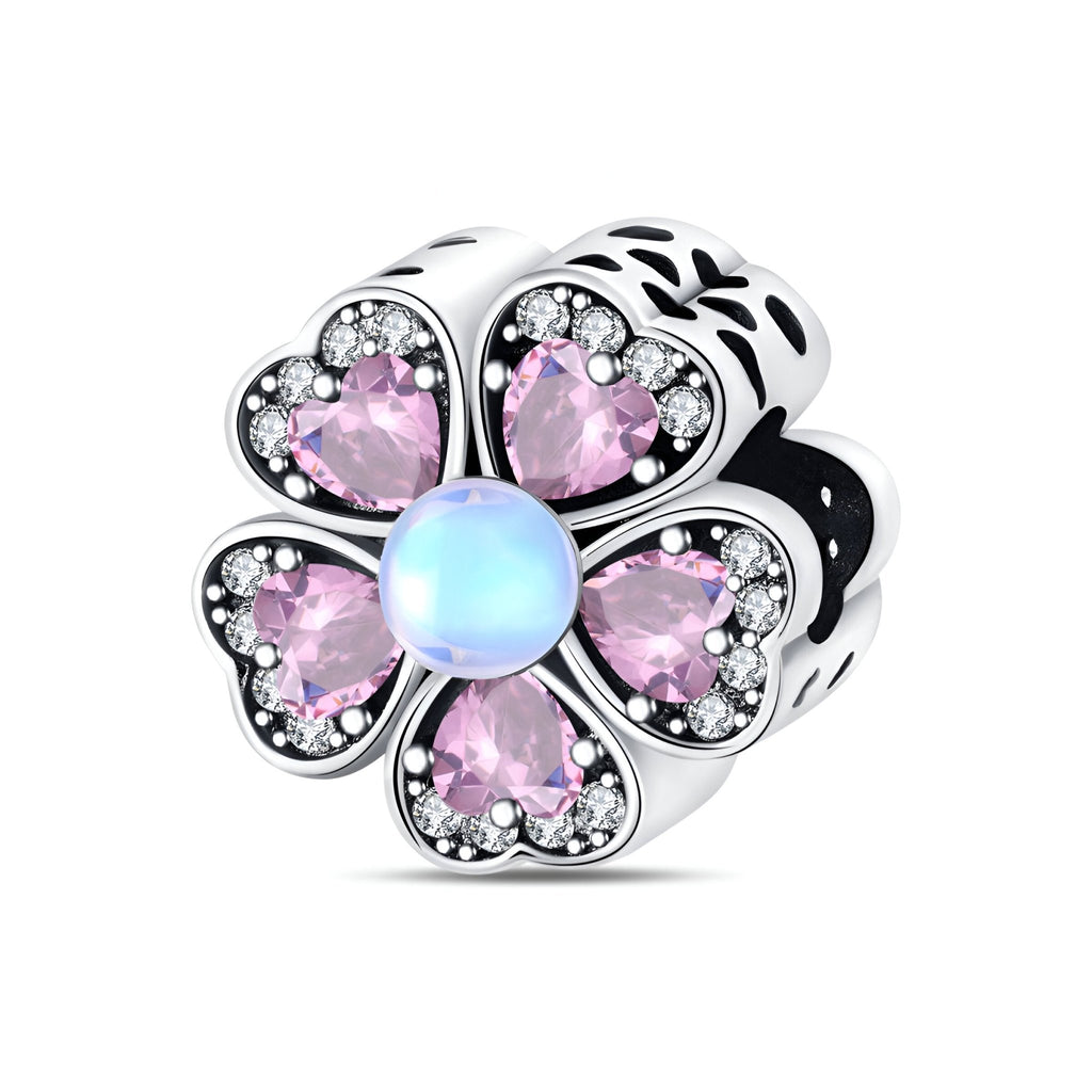 Charm en forme de fleur avec quatre cœurs roses scintillants et un centre rond nacré bleu pâle en argent.