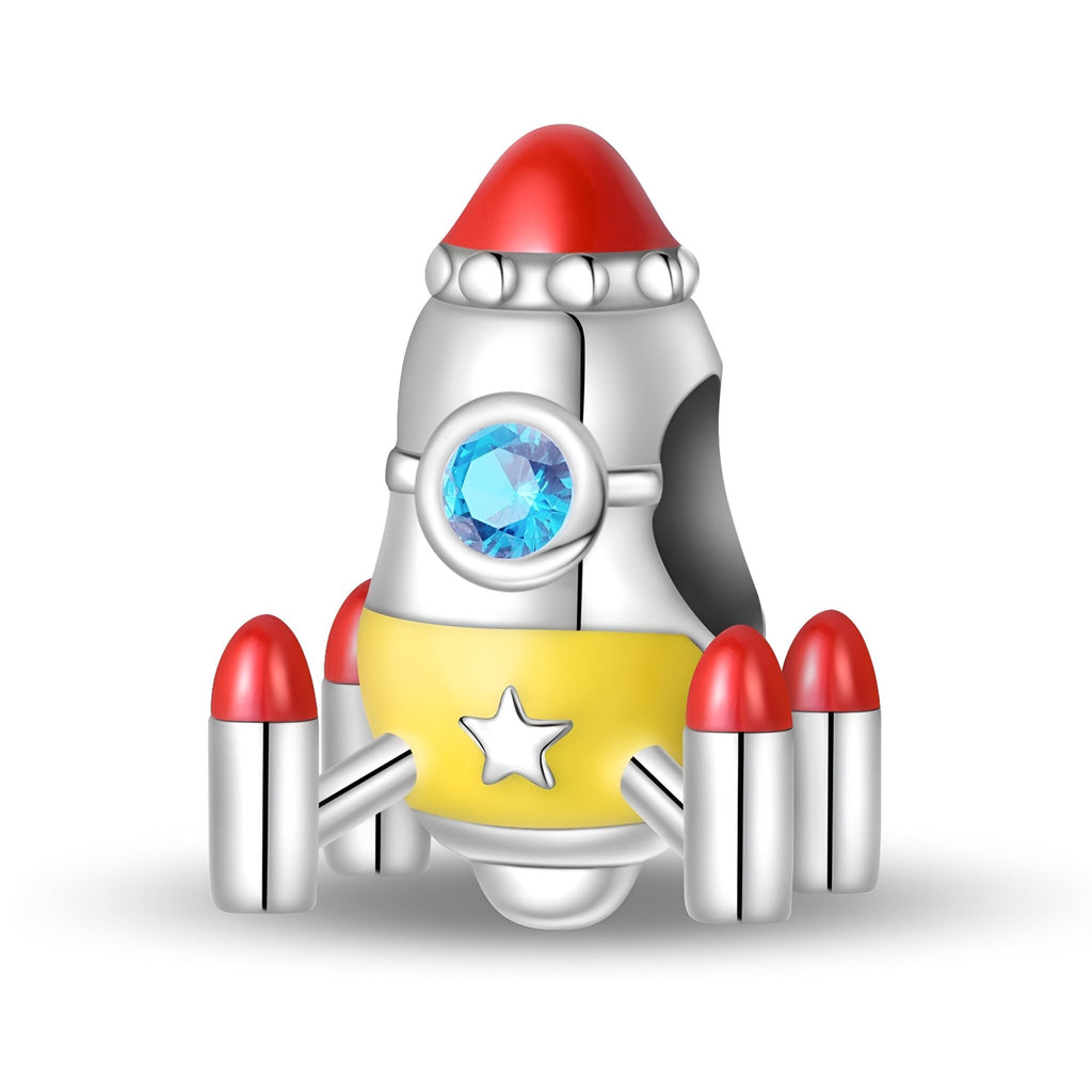 Charm fusée spatiale en métal argenté avec détails rouges et étoile jaune, pierre bleue centrale.