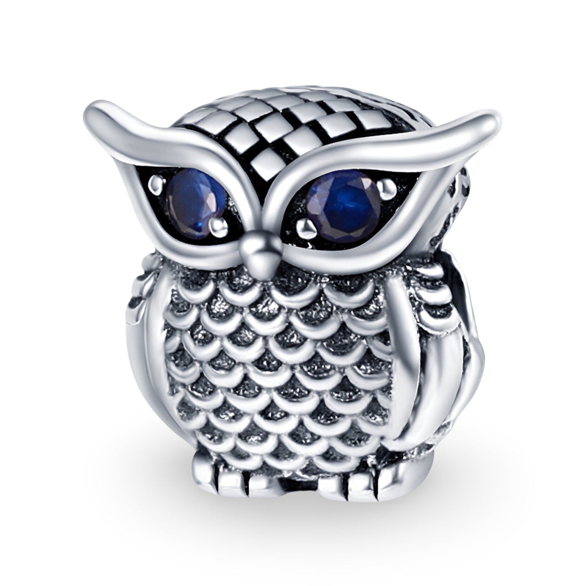 Charm hibou en métal argenté avec yeux bleus facettés et détails texturés écailles.