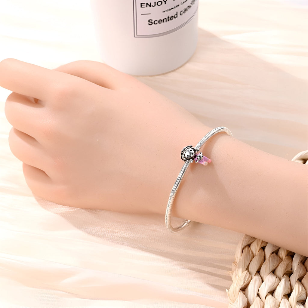 Bracelet argenté fin avec charm ballon de football noir et blanc et petite étoile rose en pendentif.