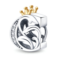 Charm lettre C en argent avec détails floraux et couronne dorée ornée de petits cristaux blancs.