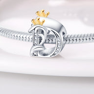 Charm lettre D en argent avec petites pierres incrustées et couronnes dorées, style Diana.