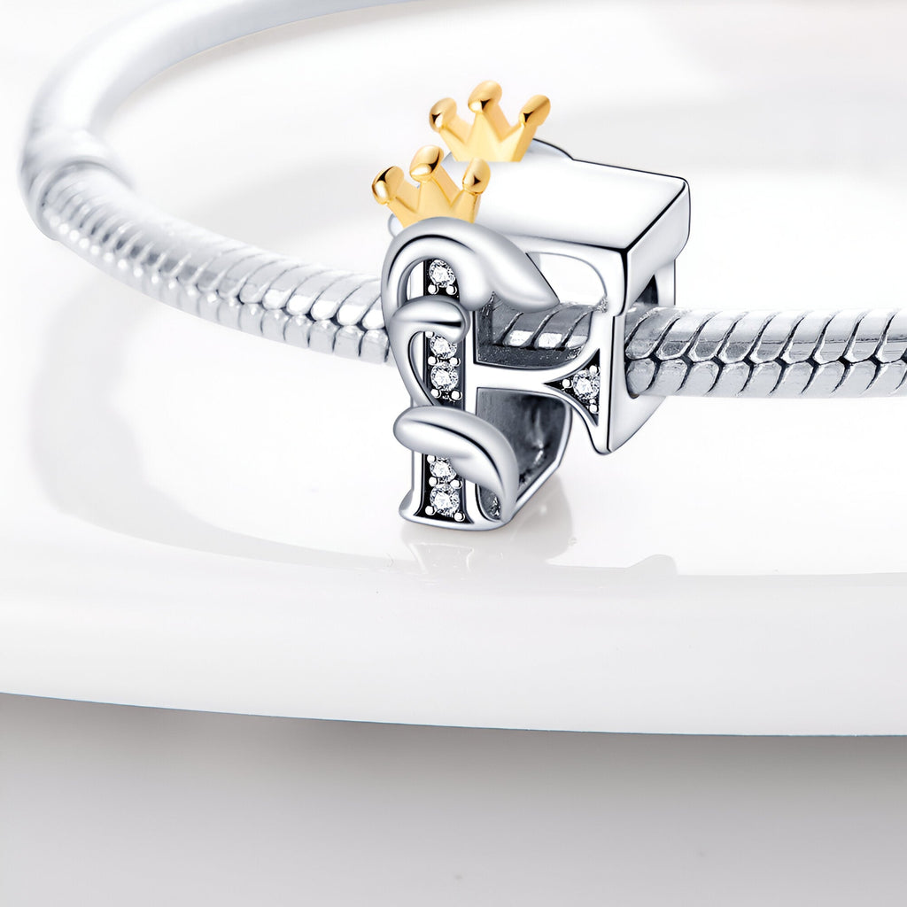 Charm lettre F en argent avec couronne dorée et petits cristaux, monté sur chaîne serpent en argent.