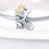 Charm lettre K en argent orné de cristaux avec couronne dorée, monté sur bracelet serpent argenté.