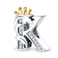 Charm lettre K en argent avec couronne dorée et incrustations de pierres brillantes.