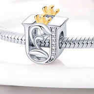Charm lettre U en argent avec couronne dorée et détails en strass sur bracelet serpent acier.
