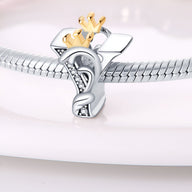 Charm lettre Y en argent avec couronne dorée et détails en zircon sur bracelet serpent argenté.