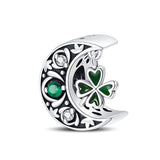 Charm en forme de lune argentée avec trèfle vert et strass blancs éclatants.