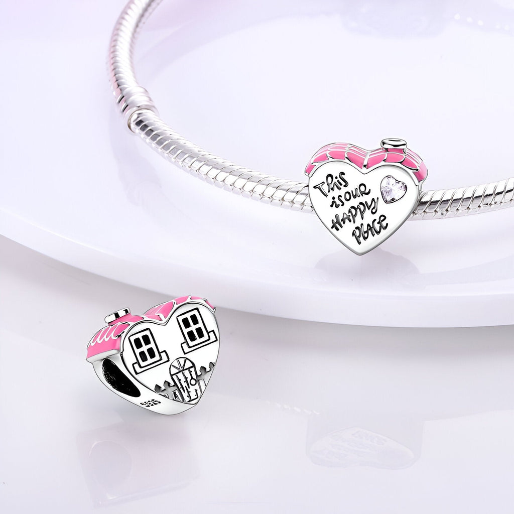 Charm en argent en forme de maison avec toit rose et détails gravés, monté sur bracelet en argent.