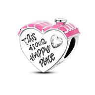 Charm cœur en argent avec émail rose et inscription "This is our happy place" avec petit cœur gravé transparent.