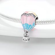 Charm montgolfière en argent avec émail rose, bleu et jaune, détails strass sur bracelet serpent argenté.