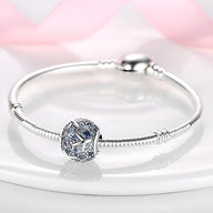 Bracelet argenté avec charm multiple en forme d’avions bleu et argent, style moderne.