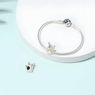 Bracelet argenté avec charm forme couronne et perle bleue étincelante, design délicat.