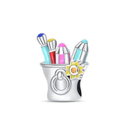 Charm argenté en forme de pot de peinture avec pinceaux colorés et fleur jaune détaillée.