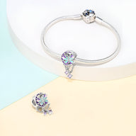 Charm papillon multicolore en cristal avec pendentifs argentés, bracelet serpent argenté fin.