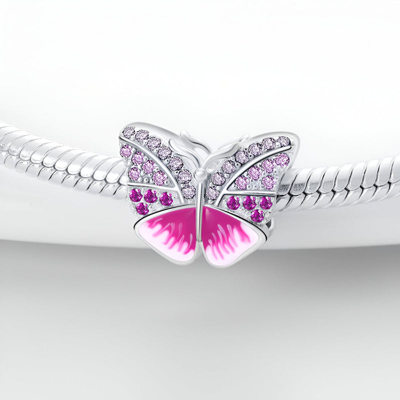 Charm papillon en argent avec détails roses et pierres scintillantes, modèle Anatolia.