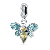 Pendentif abeille argenté avec aile émaillée bleu turquoise et corps orné de pierres taillées jaunes.