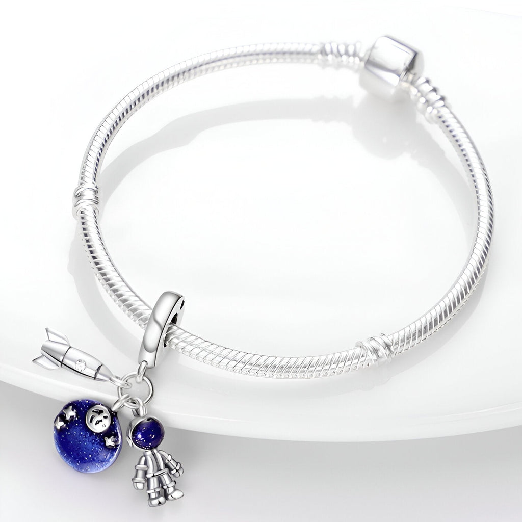 Bracelet argenté avec pendentif charme d’astronomie bleu nuit et petit astronaute argenté.