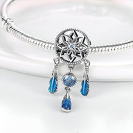 Charm pendentif attrape-rêves argent avec pierres bleues et plumes suspendues sur bracelet serpent.