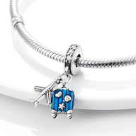 Charm pendentif argenté avion et valise bleue avec étoiles, sur bracelet serpent argenté.