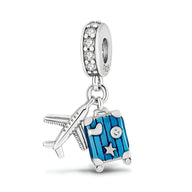 Charm pendentif argent avion et valise bleue à rayures avec étoiles et cristaux blancs.