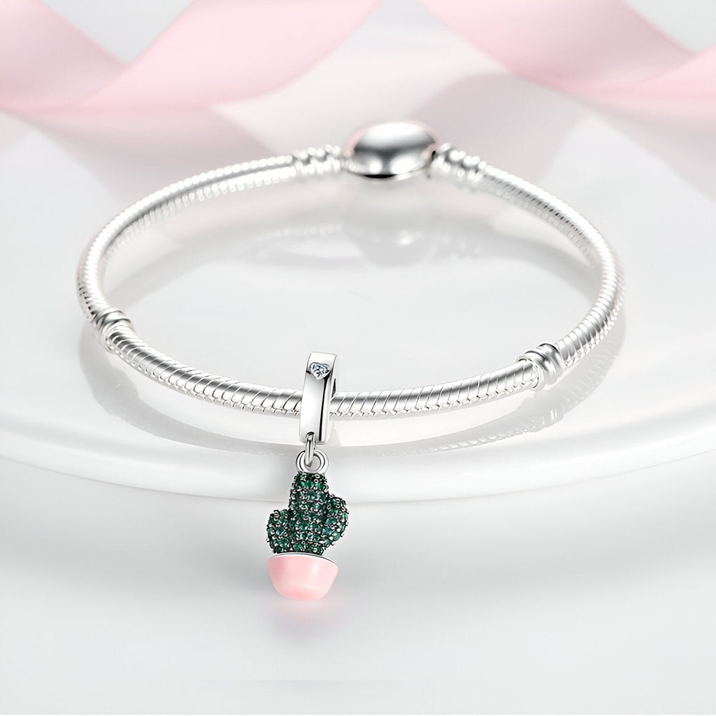 Bracelet argenté avec pendentif cactus vert orné de strass et pot rose pâle.