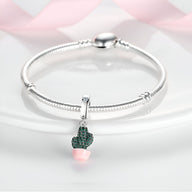 Bracelet argenté avec pendentif cactus vert orné de strass et pot rose pâle.