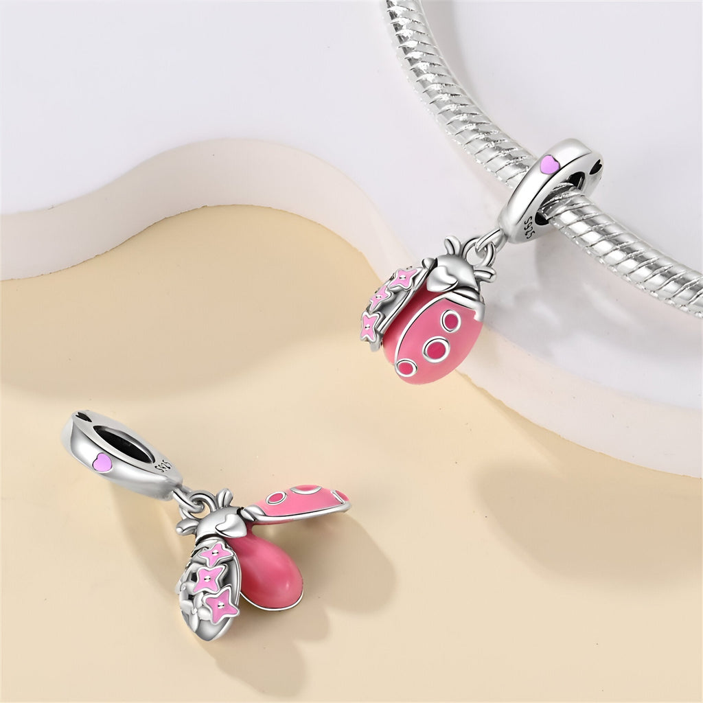 Charm pendentif coccinelle en argent avec ailes émaillées rose et détails lumineux, modèle Helmina.