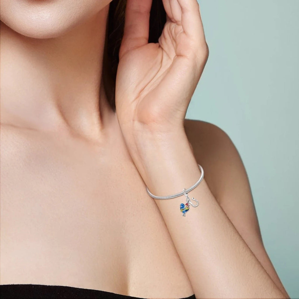 Bracelet fin argenté avec pendentif petit coq rouge et fer à cheval doré.