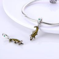 Charm pendentif crocodile doré avec yeux verts, détail écailles réaliste, style élégant féminin.